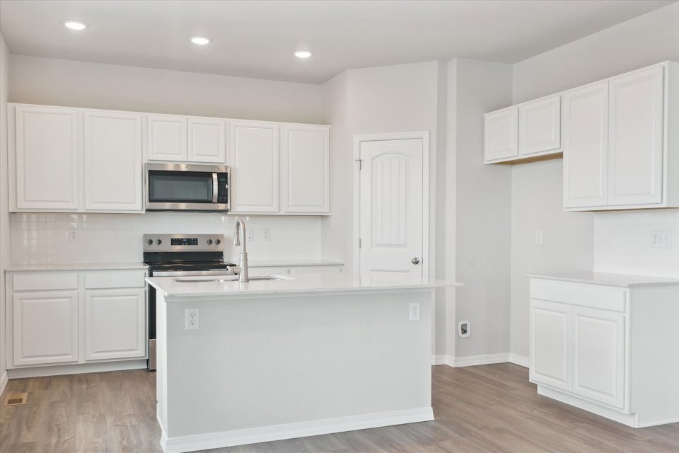 A kitchen with white cabinets.