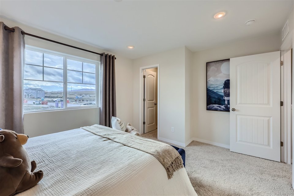 A bedroom with a large window.