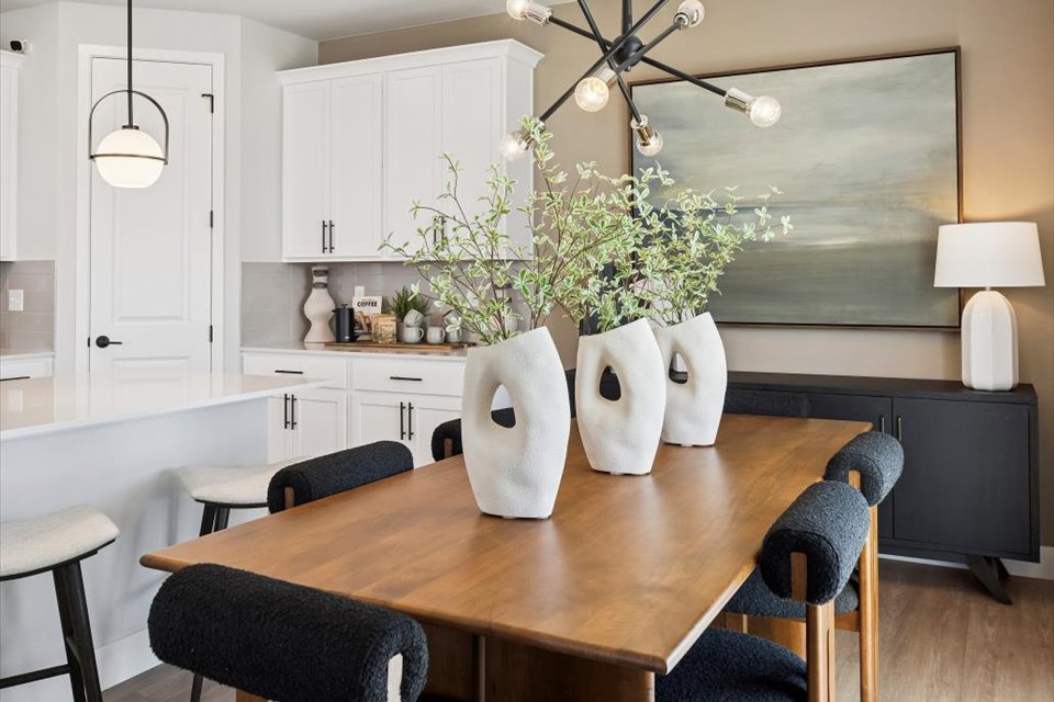 A dining room table with a vase of flowers on it.