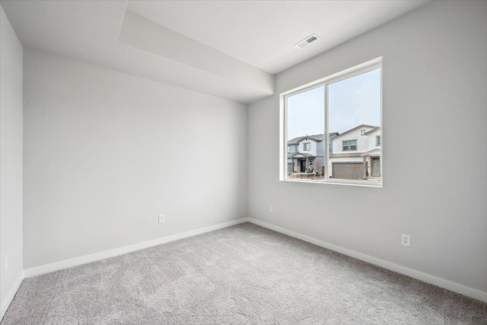 A room with a window and a carpet.