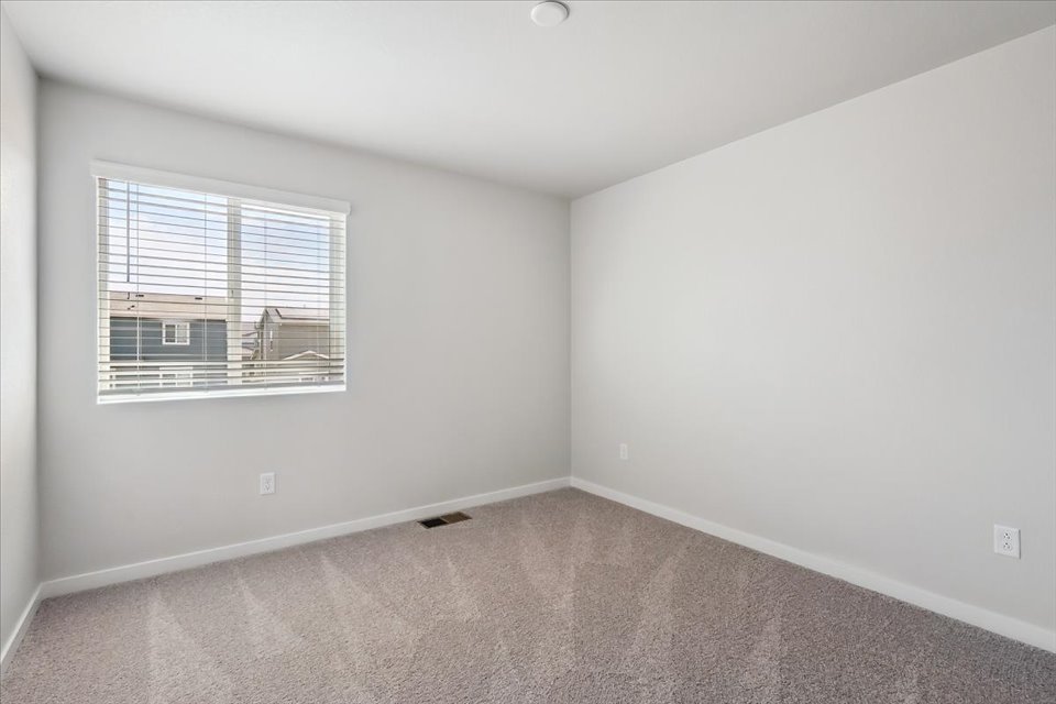 A room with a window and a carpet.