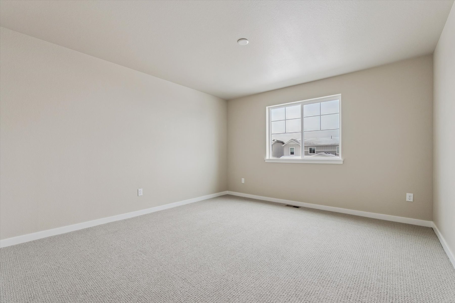 A room with a window and a carpet.