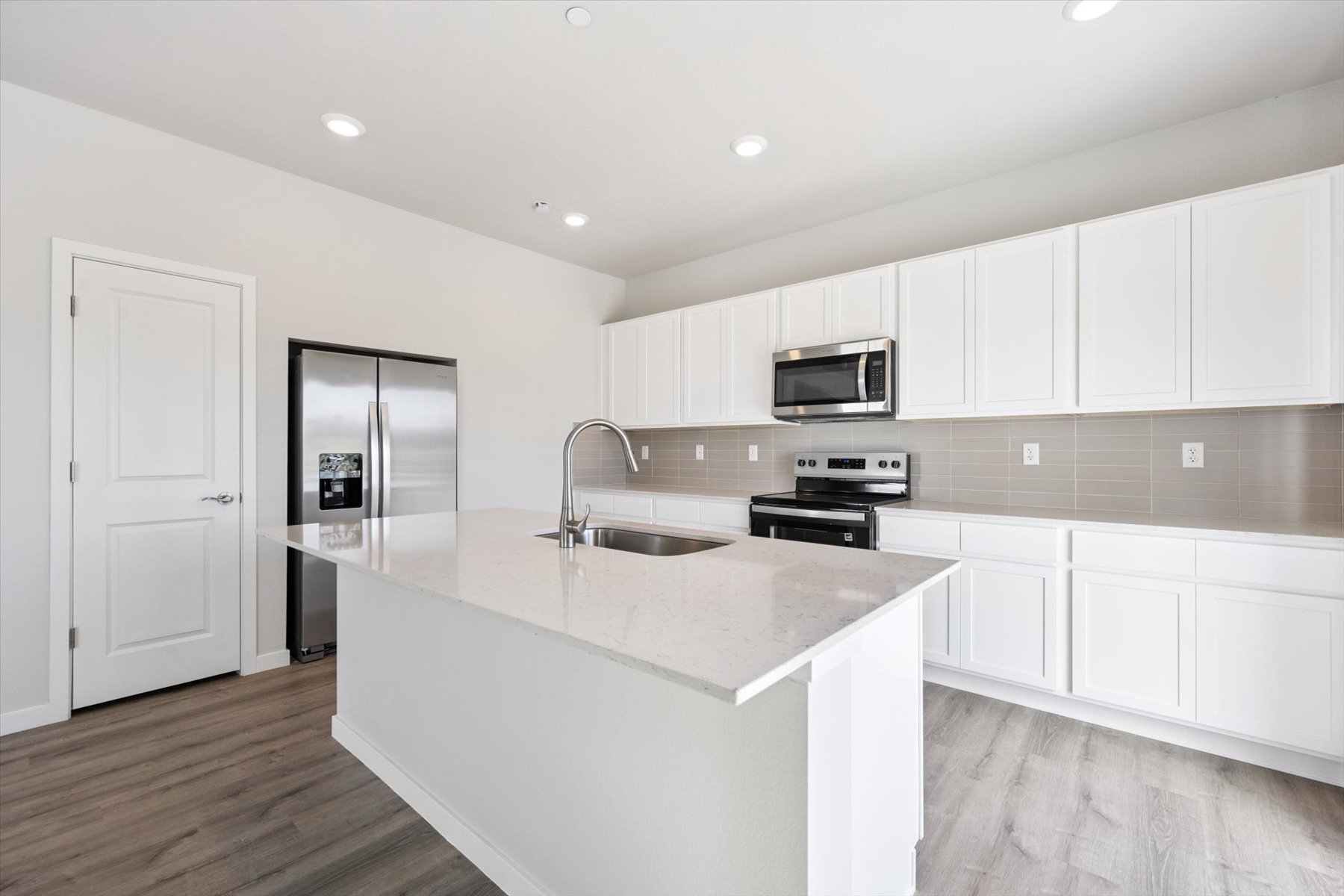 A kitchen with white cabinets.