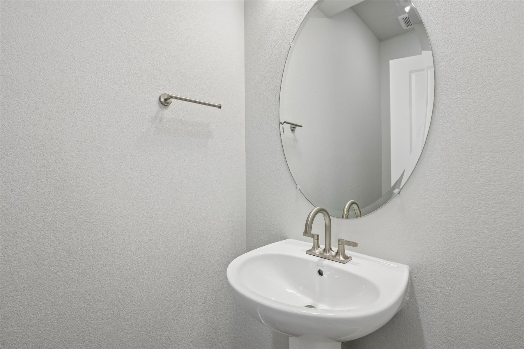 A bathroom with a round mirror.