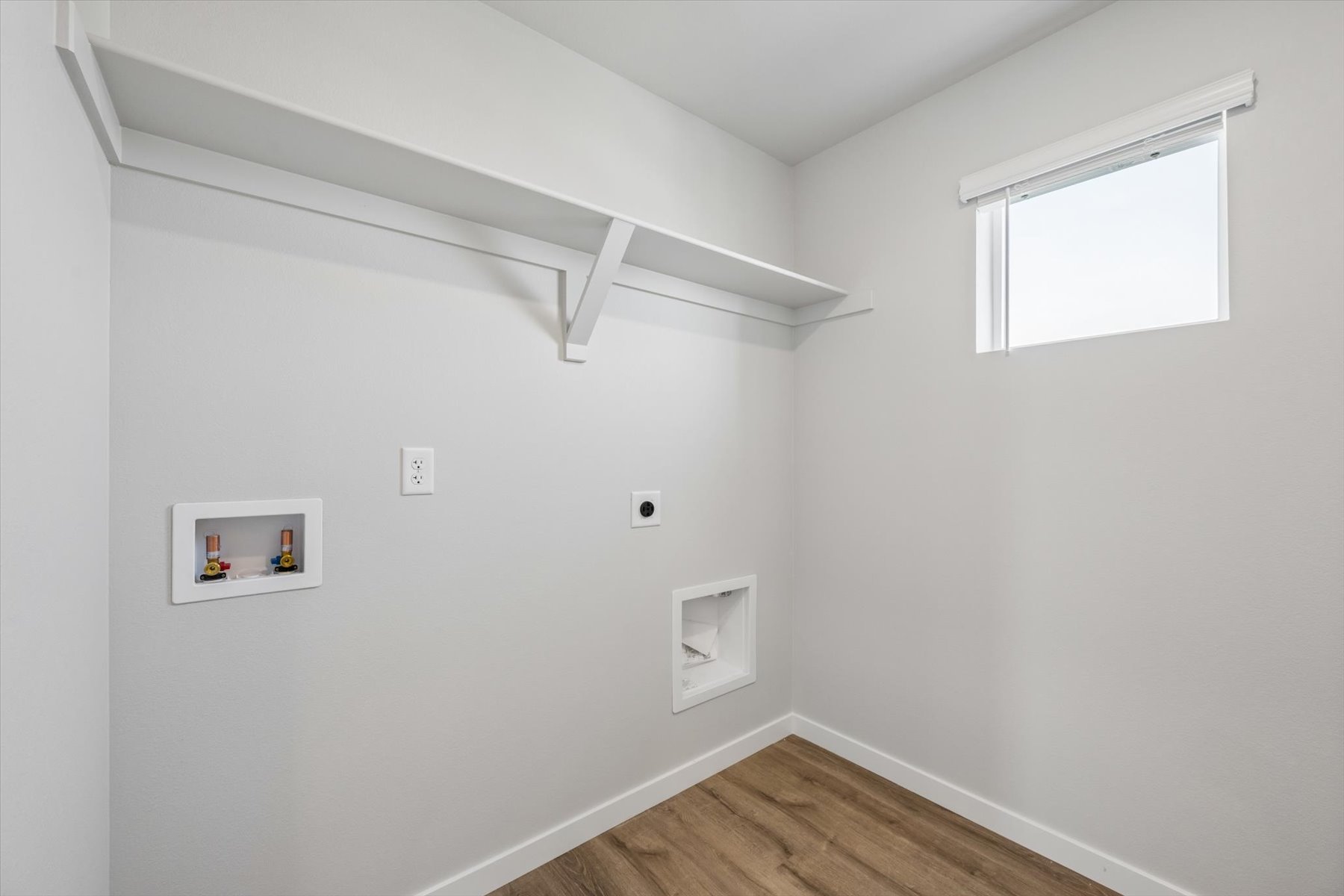 A white room with a wood floor and a wood floor.