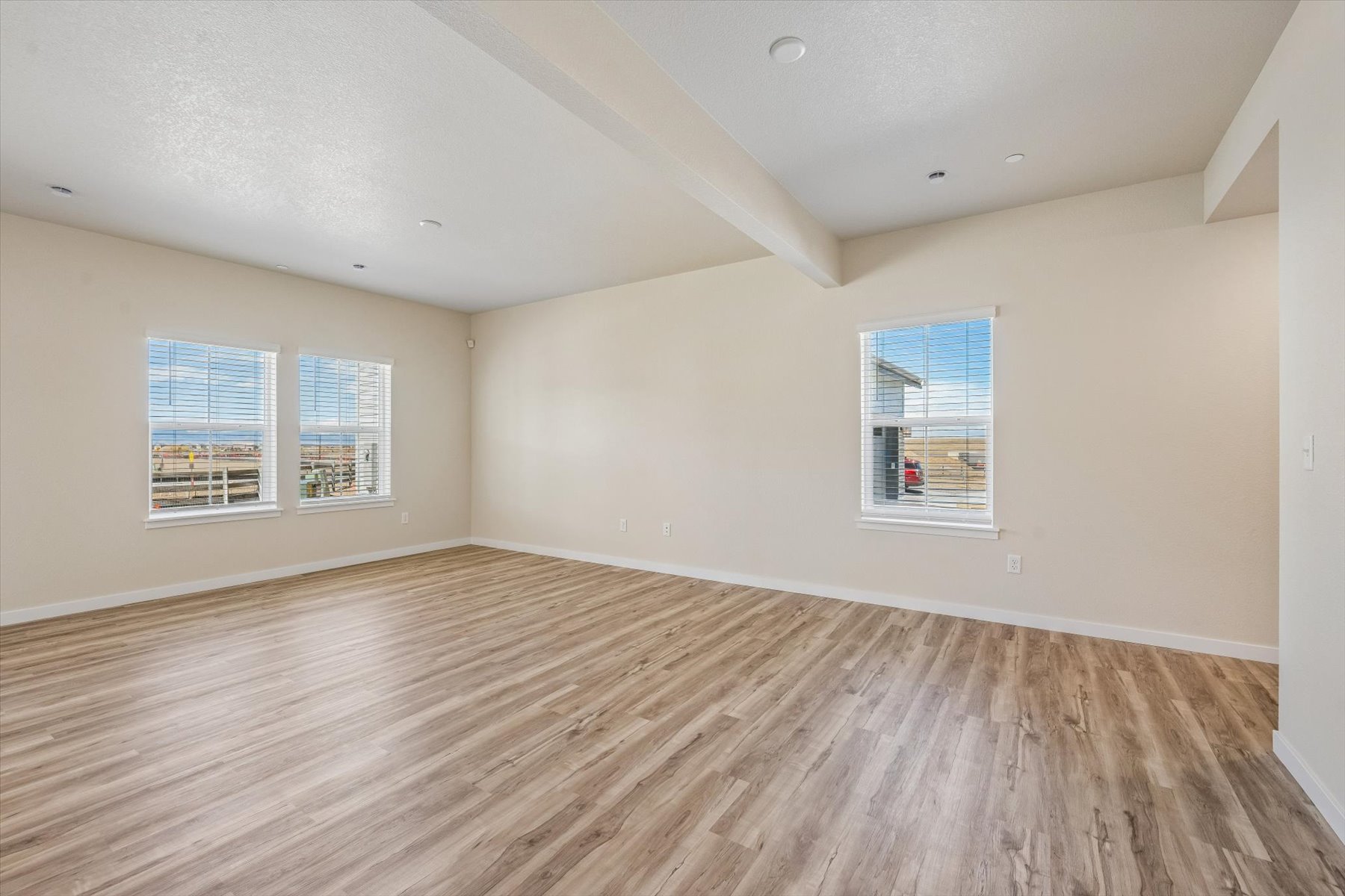 A room with a wood floor and windows.
