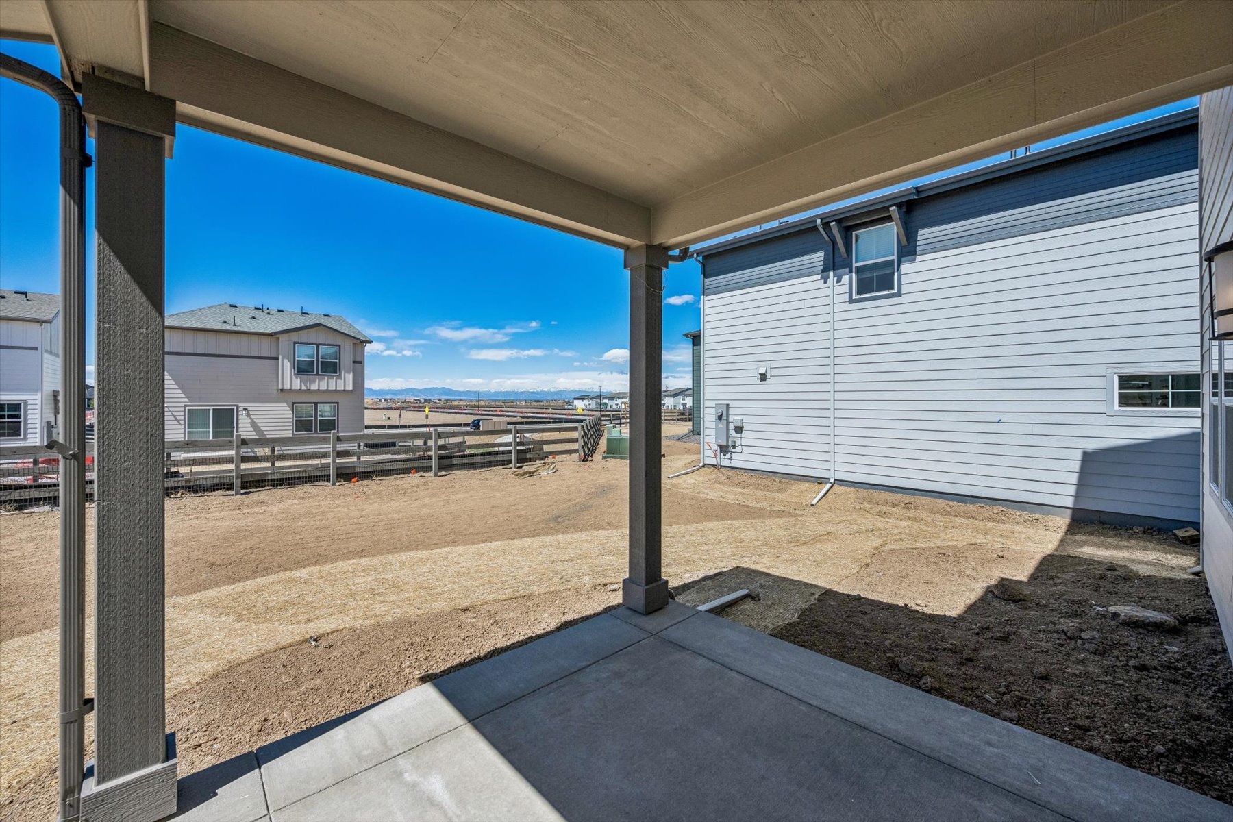 A building with a fence and a dirt field.