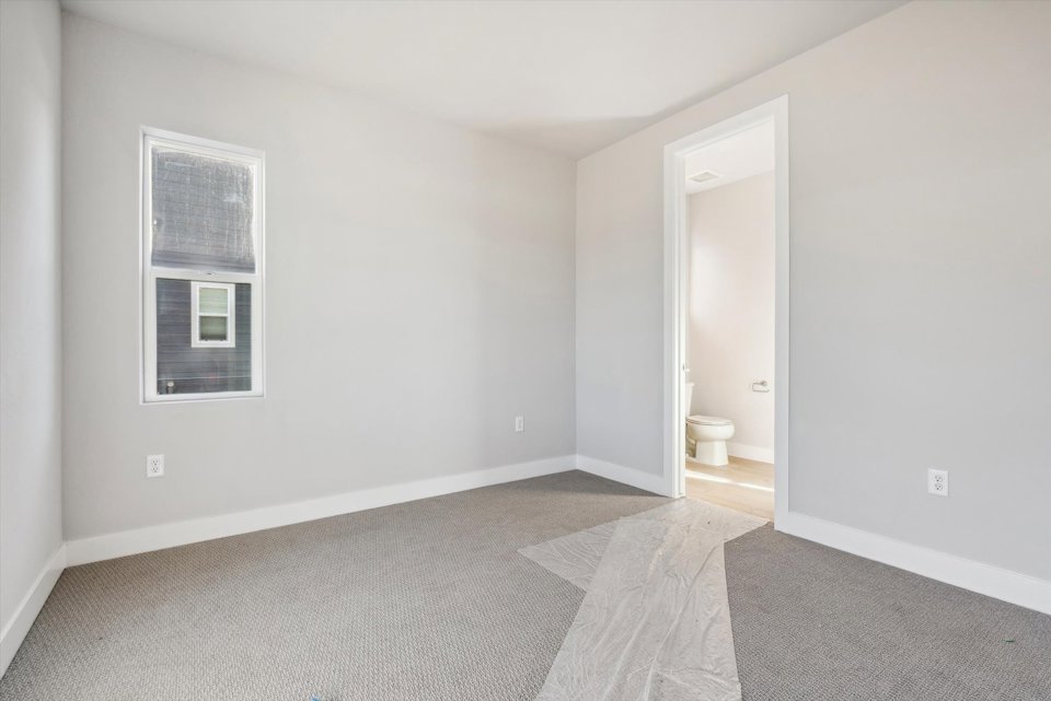 A bathroom with a toilet and a rug.