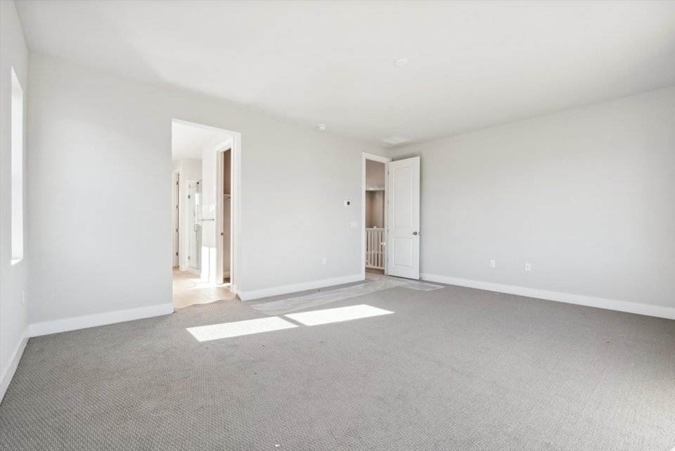 A long hallway with white doors.