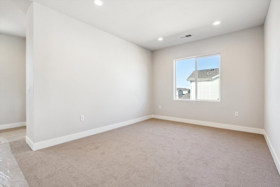 A room with a carpet and a window.