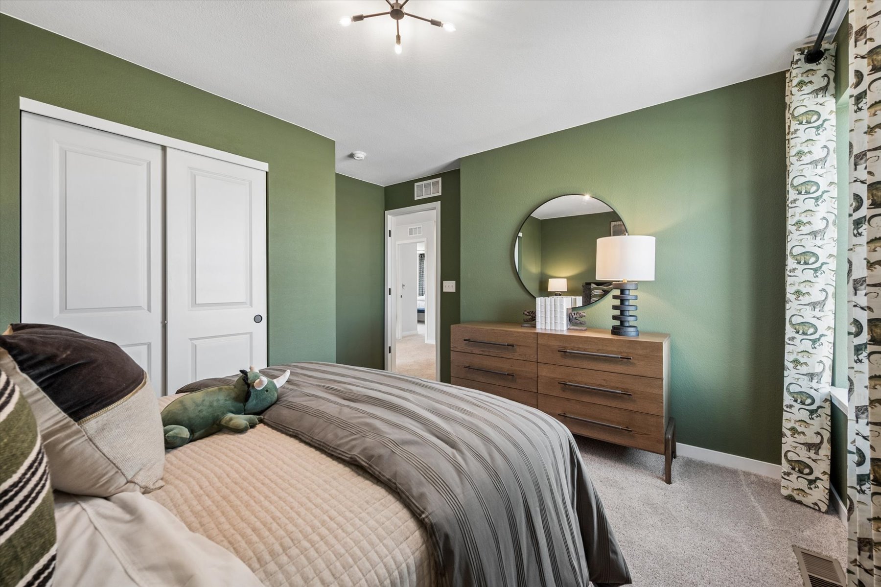 A bedroom with a bed and a mirror.