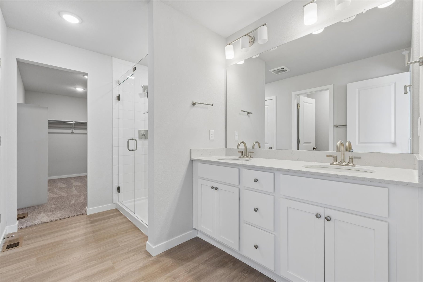 A bathroom with white cabinets.