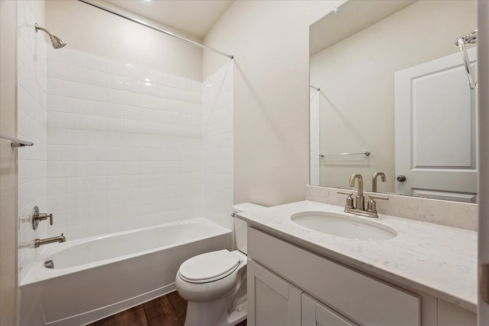 A bathroom with a tub sink and toilet.