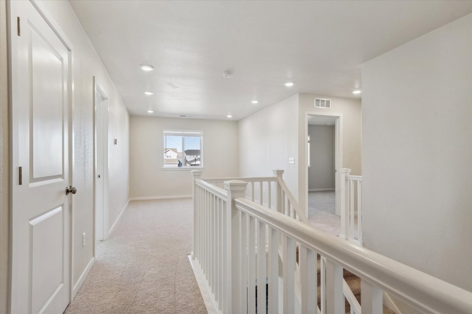 A hallway with white railings.