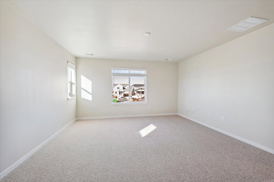 A room with a window and a white wall.