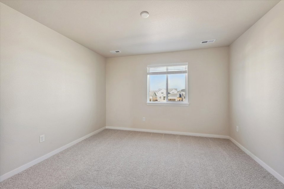 A room with a window and a carpet.