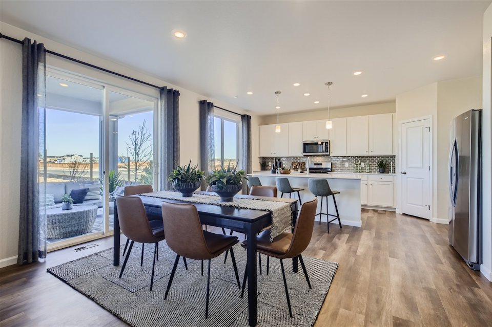 A kitchen with a dining table and chairs.