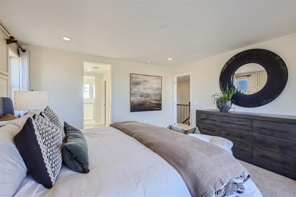 A bedroom with a large mirror.