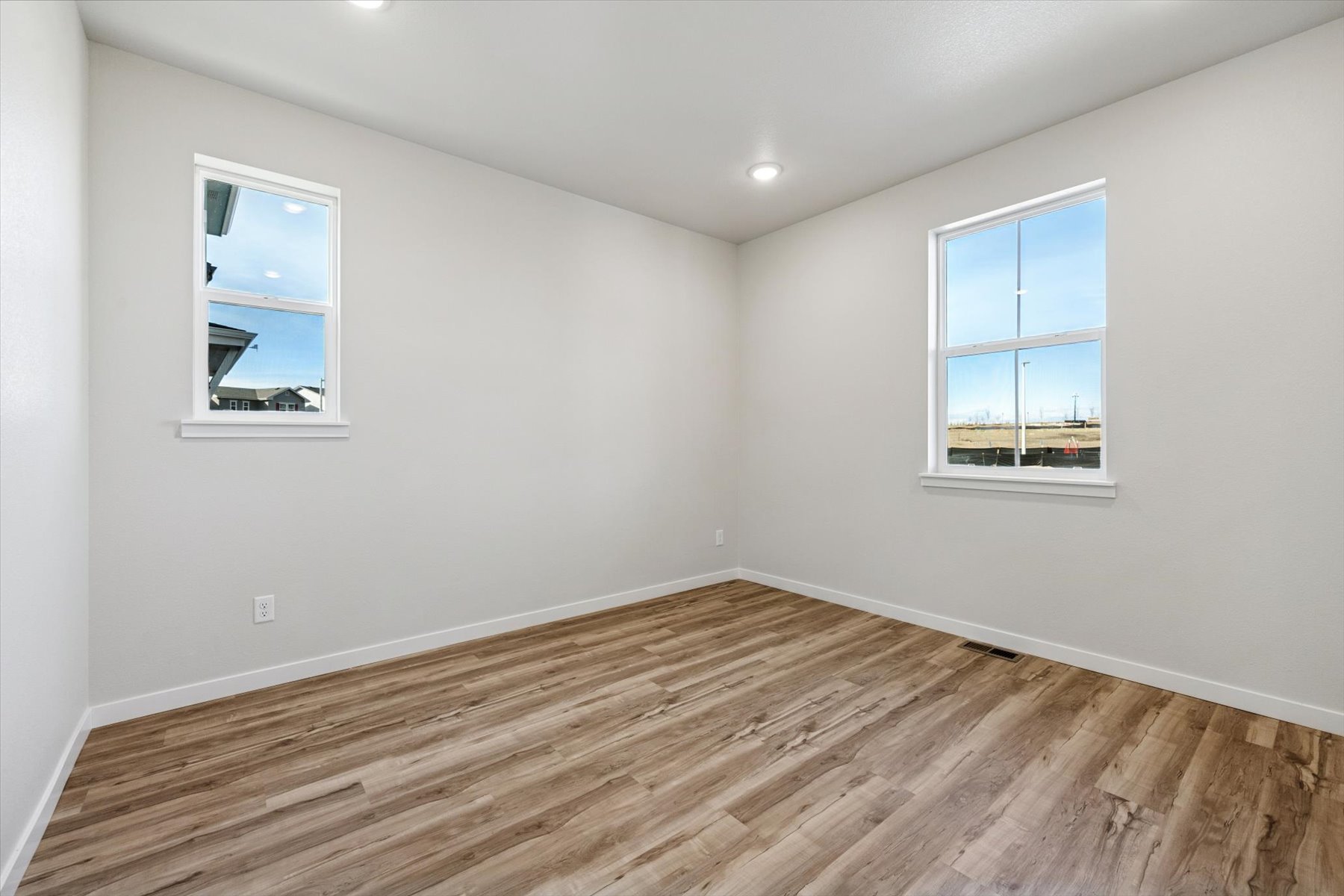 A room with a wood floor and windows.