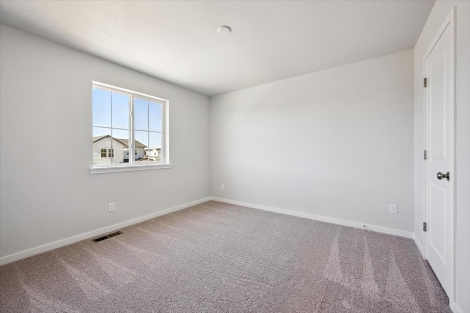 A room with a window and a carpet.