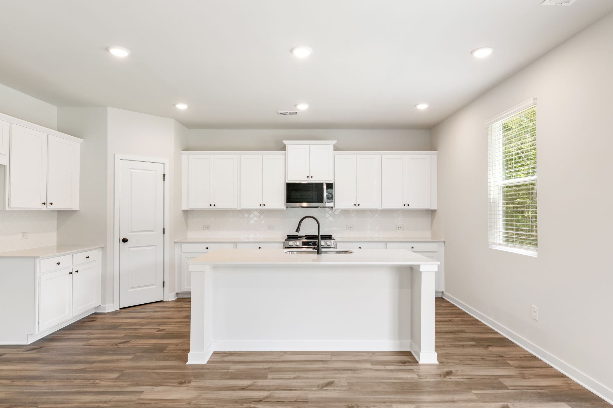 A kitchen with white cabinets.