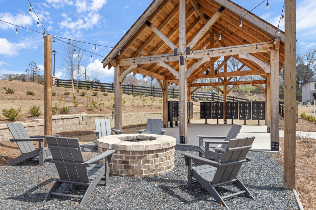 A gazebo with chairs and a table in front of it.