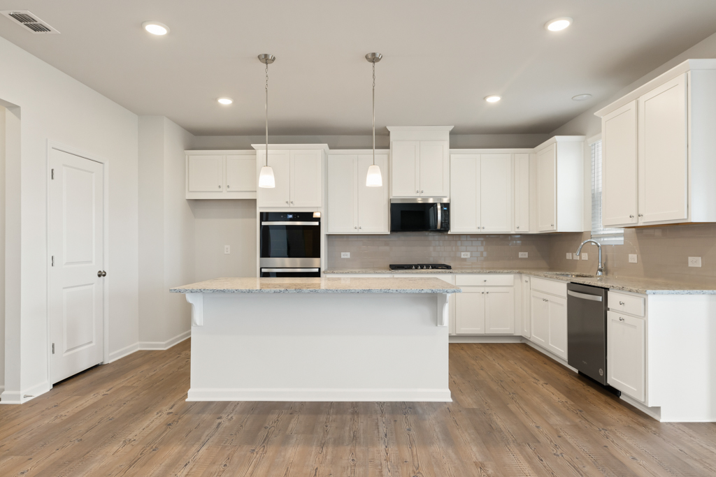 A kitchen with white cabinets.
