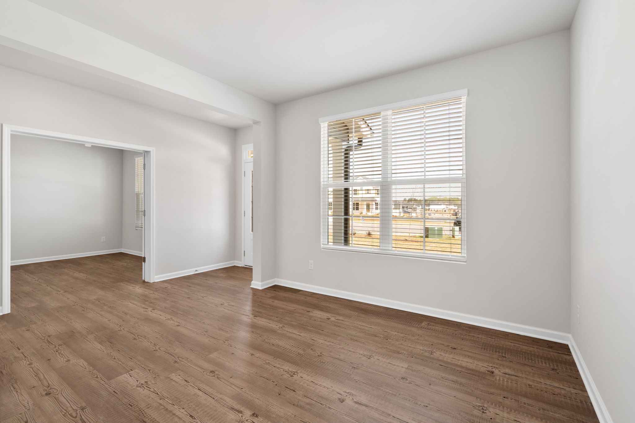 A room with a wood floor and a window.