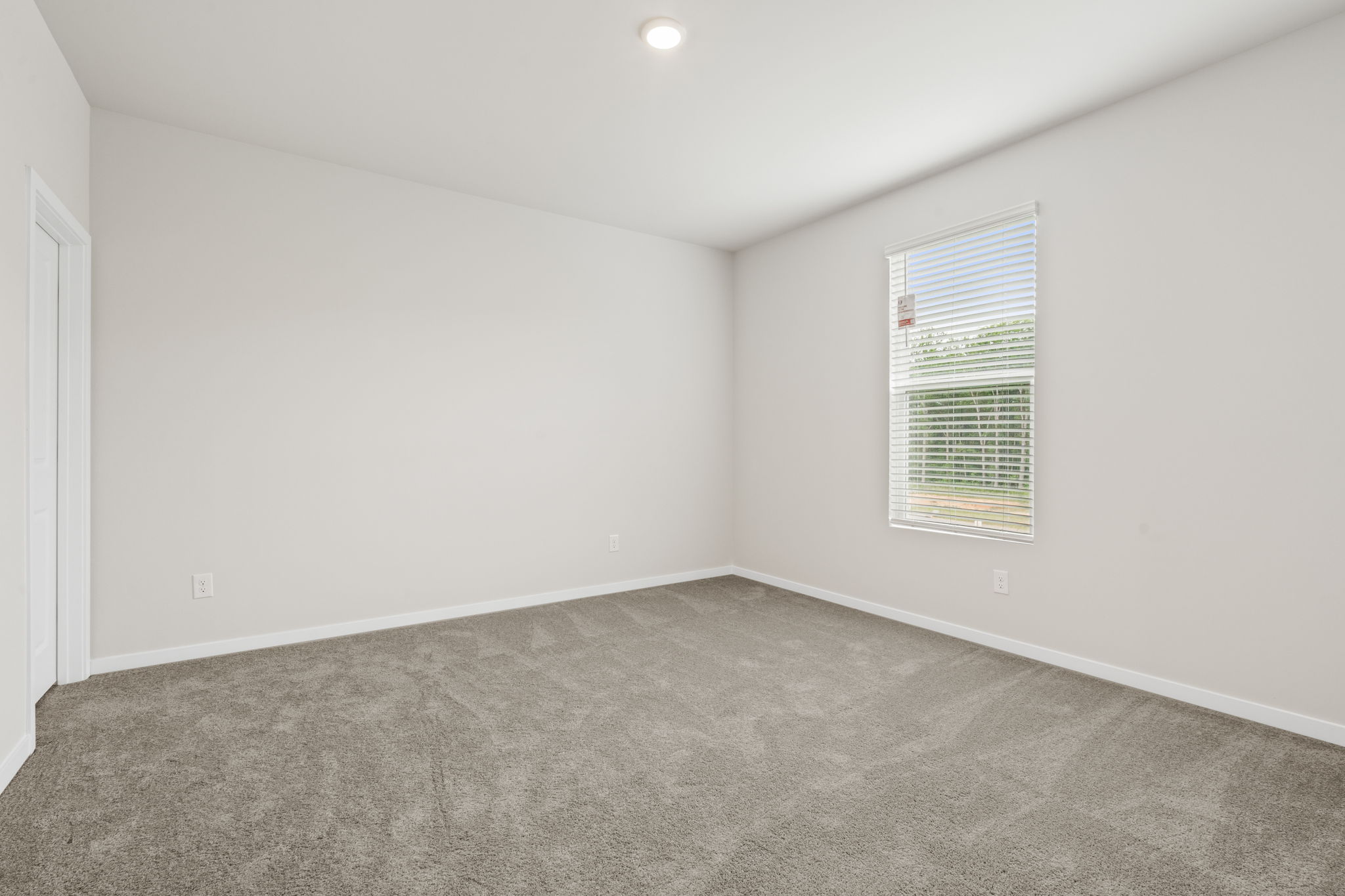 A room with a carpet and a window.