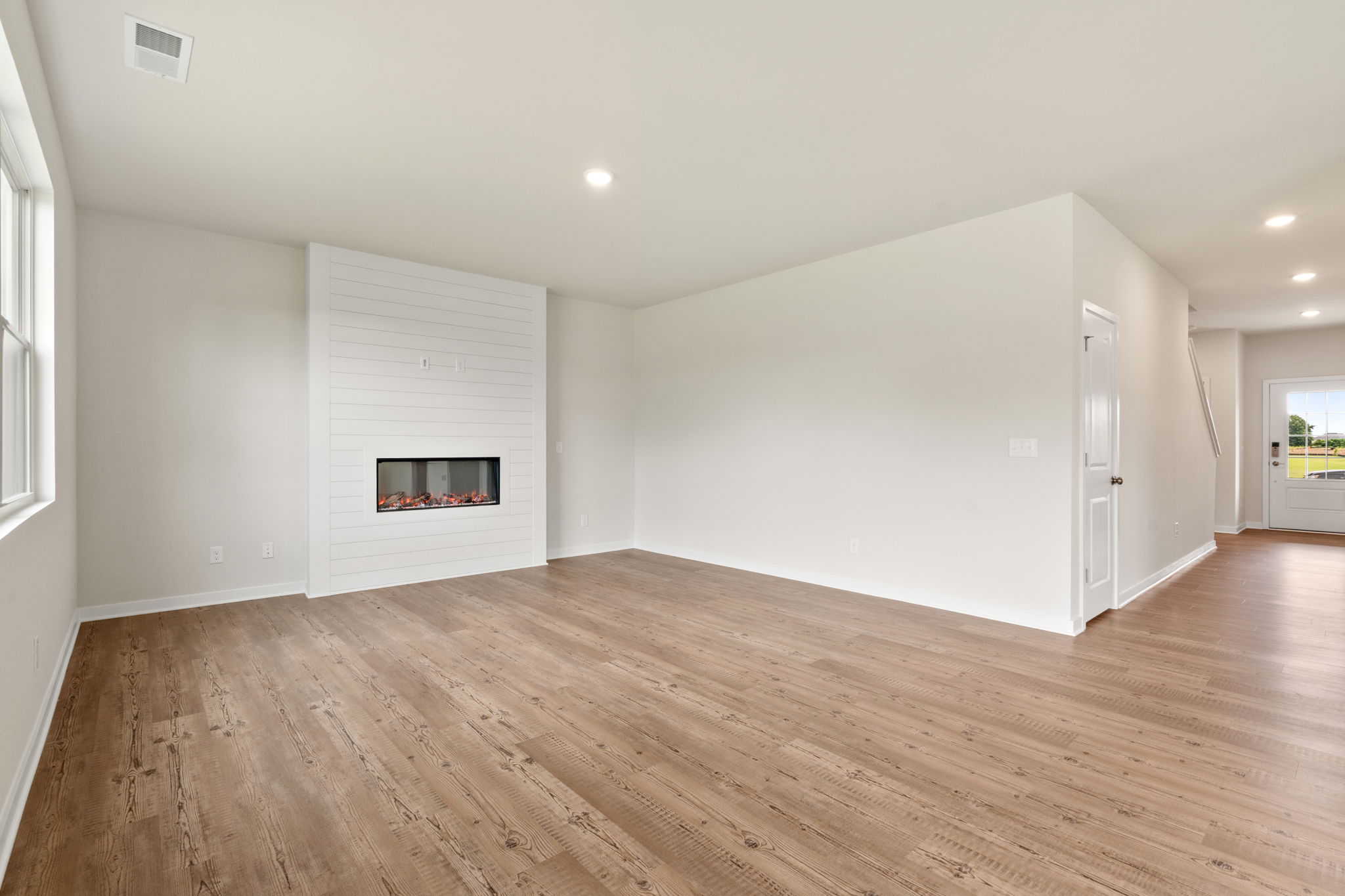 A room with a wood floor and a fireplace.