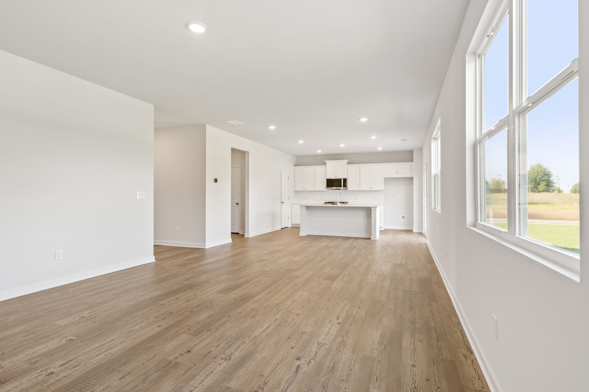 A large empty room with a wood floor and a wood floor.