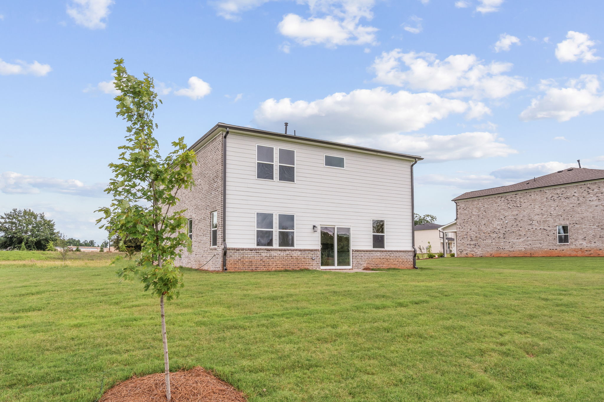 A house with a tree in the front yard.
