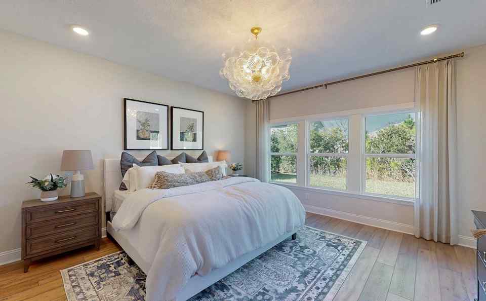 A bedroom with a bed and a chandelier.