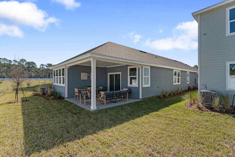 A house with a lawn and chairs.