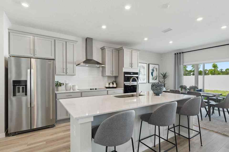 A kitchen with a dining table and chairs.