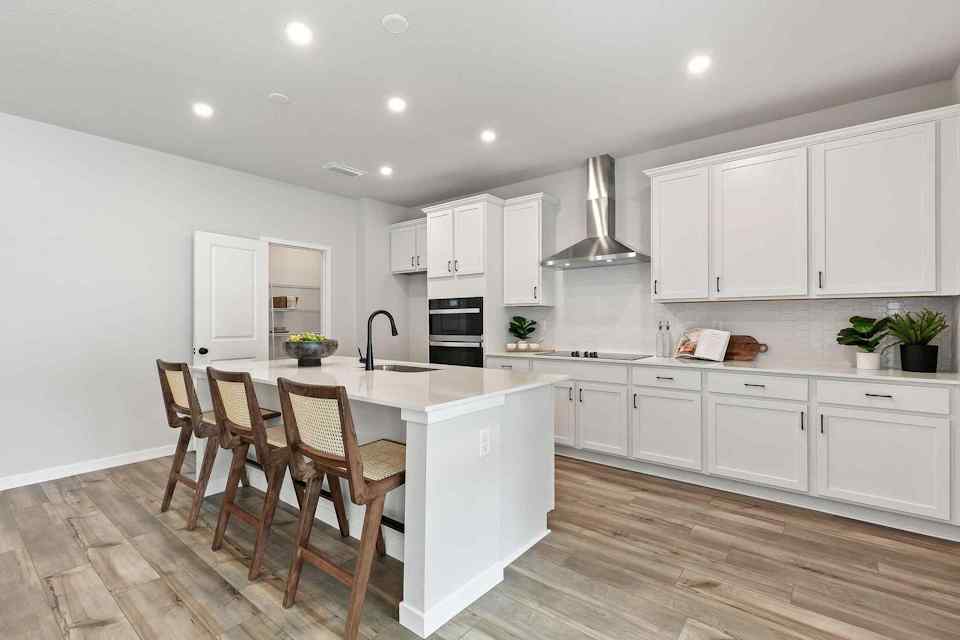 A kitchen with white cabinets.