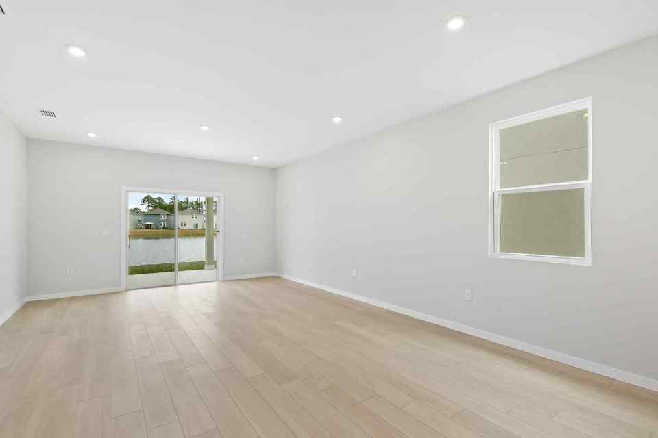 A room with a wood floor and windows.