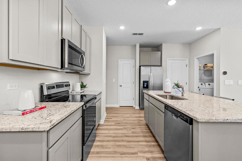 A kitchen with white cabinets.