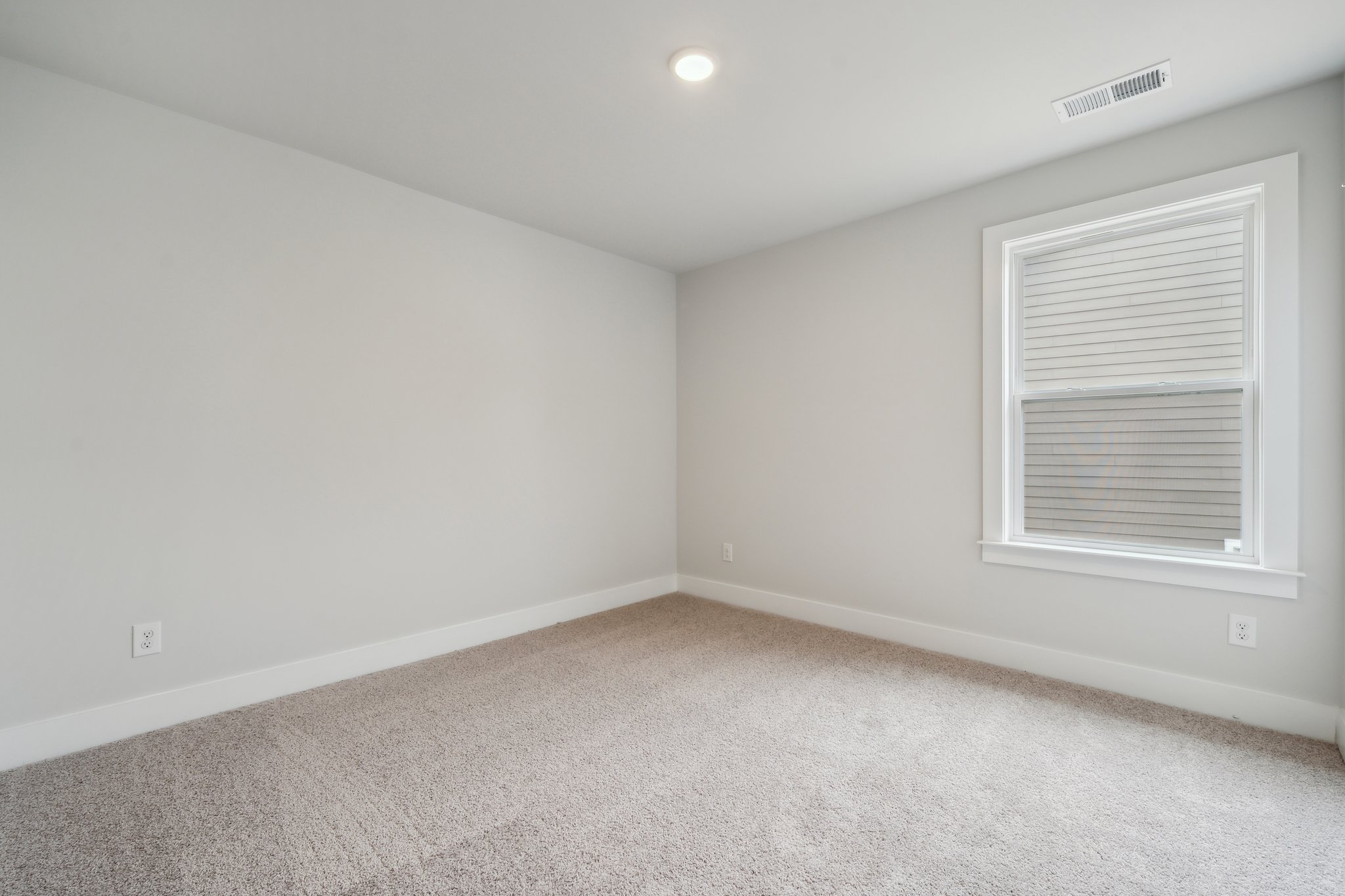 A room with a window and carpet.