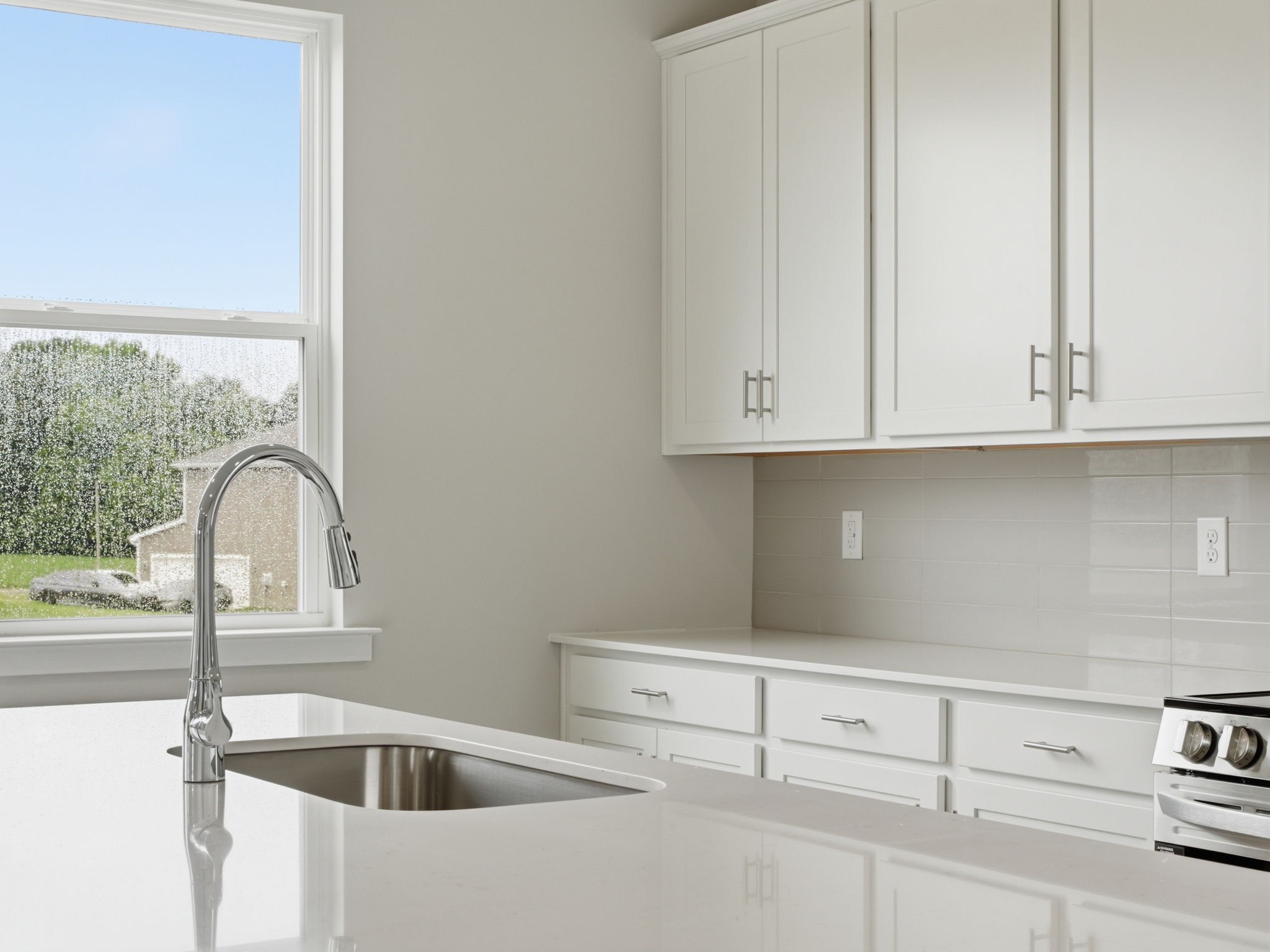 A kitchen with white cabinets.