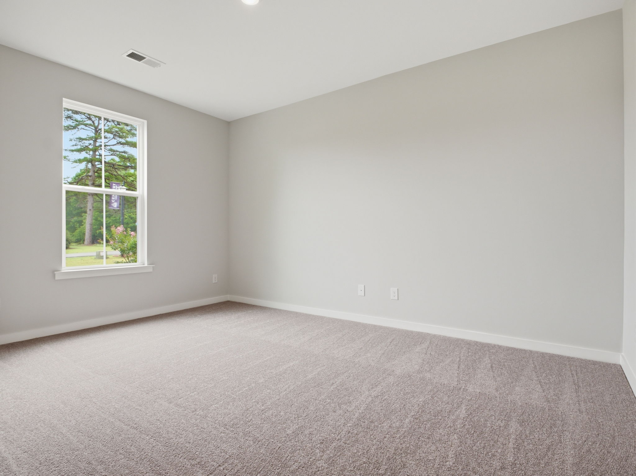 A room with a carpet and a window.