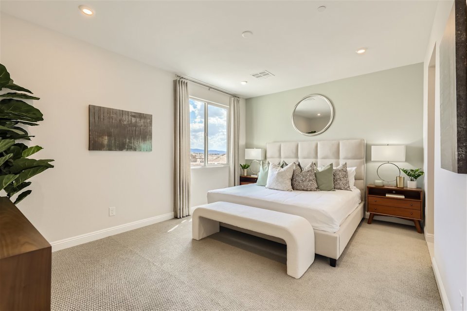 A bedroom with a bed and a mirror.