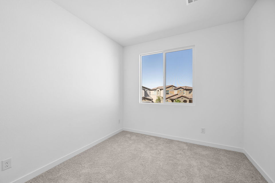 A room with a window and a carpet.