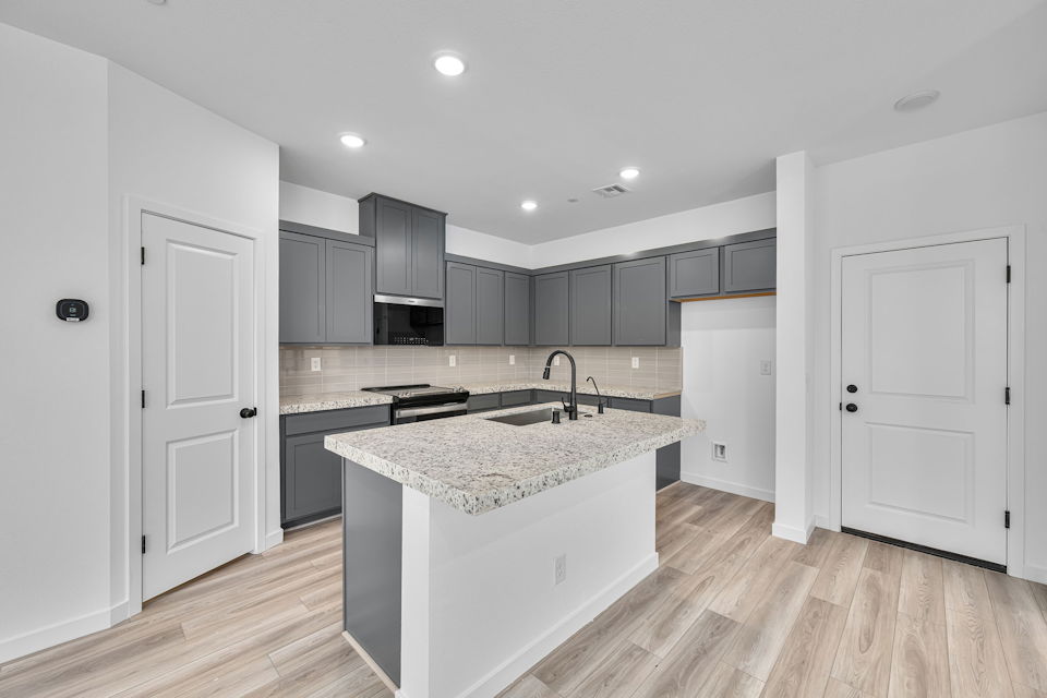 A kitchen with black cabinets.