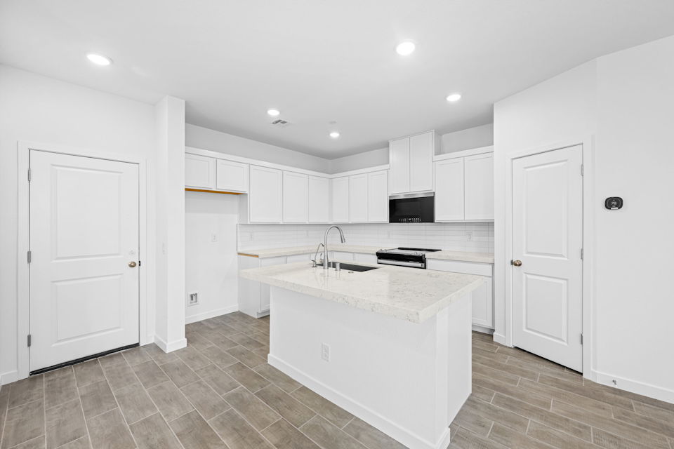 A kitchen with white cabinets.