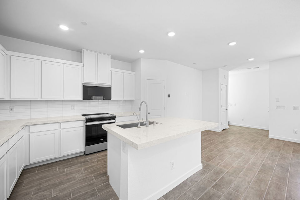 A kitchen with white cabinets.