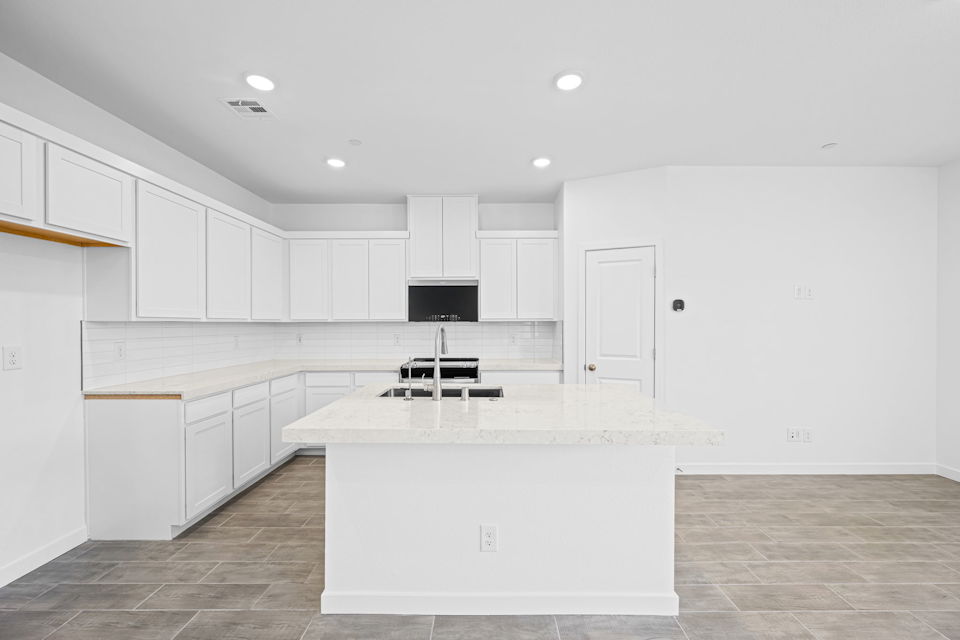 A kitchen with white cabinets.