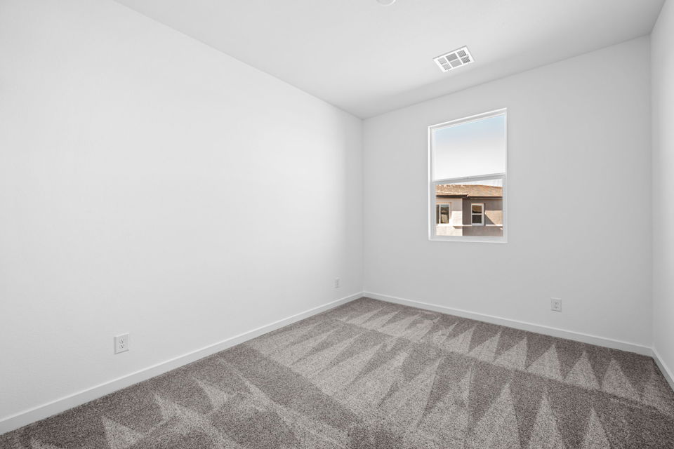 A room with a carpet and a window.