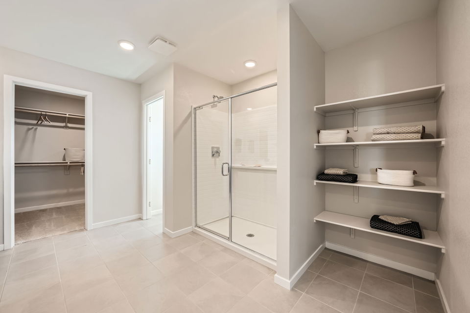 A room with a glass door and white shelves.