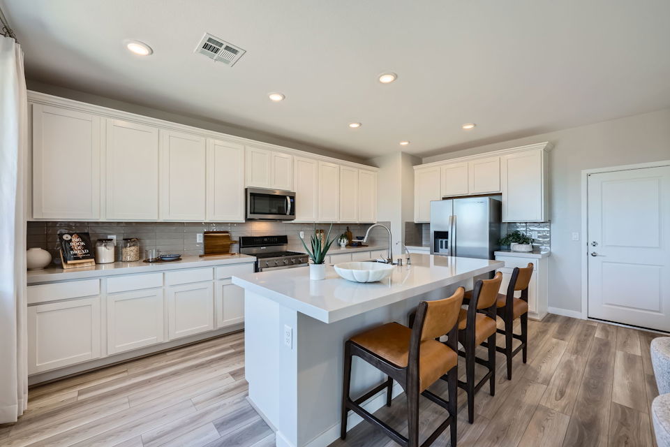A kitchen with white cabinets.